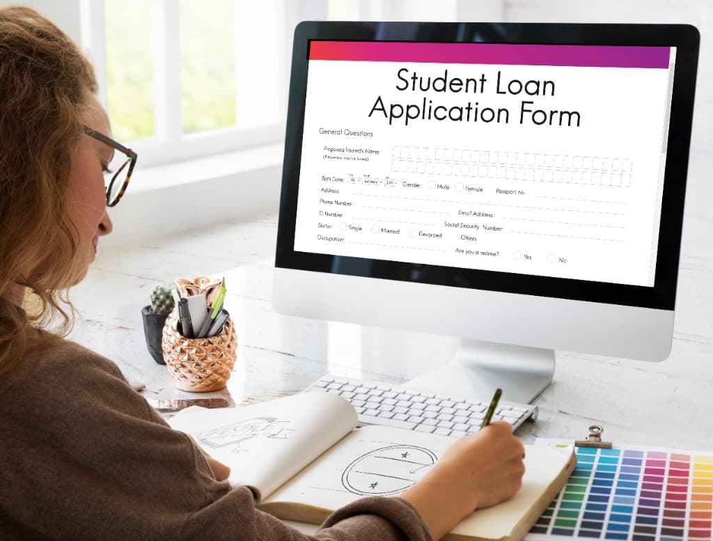Student reviewing application and funding documents at a desk